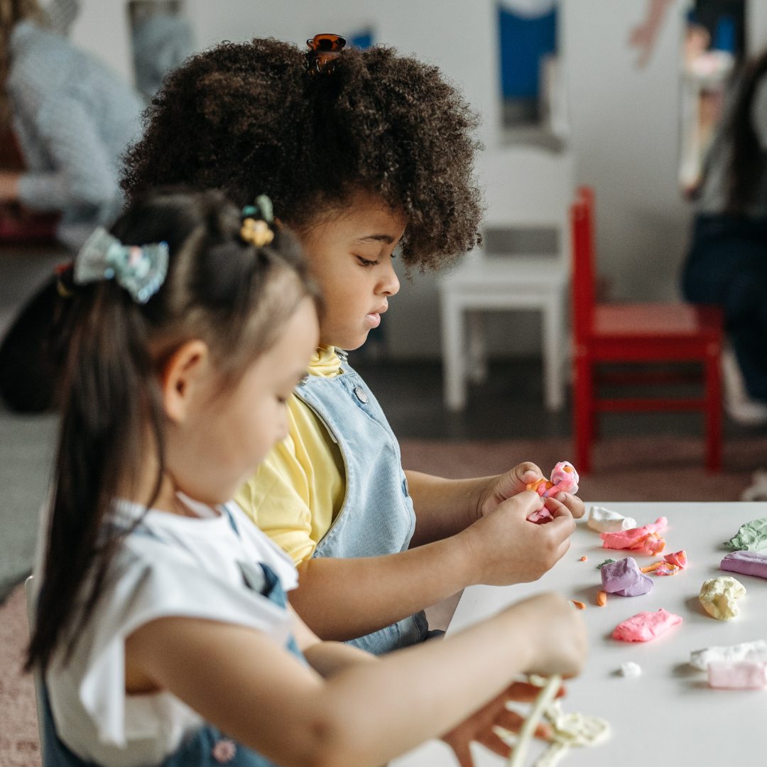 Children playing with playdough at a table