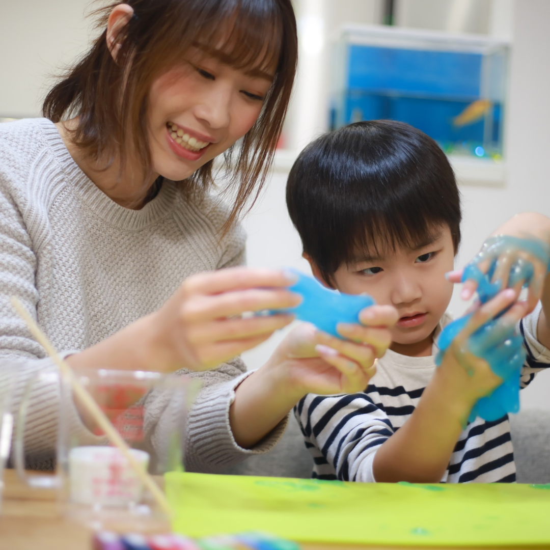 Adult and child doing sensory activity with slime - UCCC at Armitage Village PS childcare programs