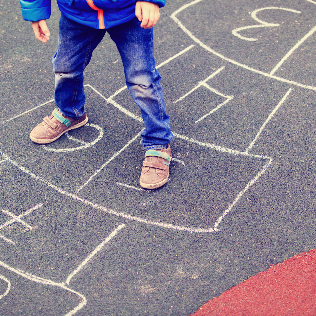 Child doing hopscotch in playground