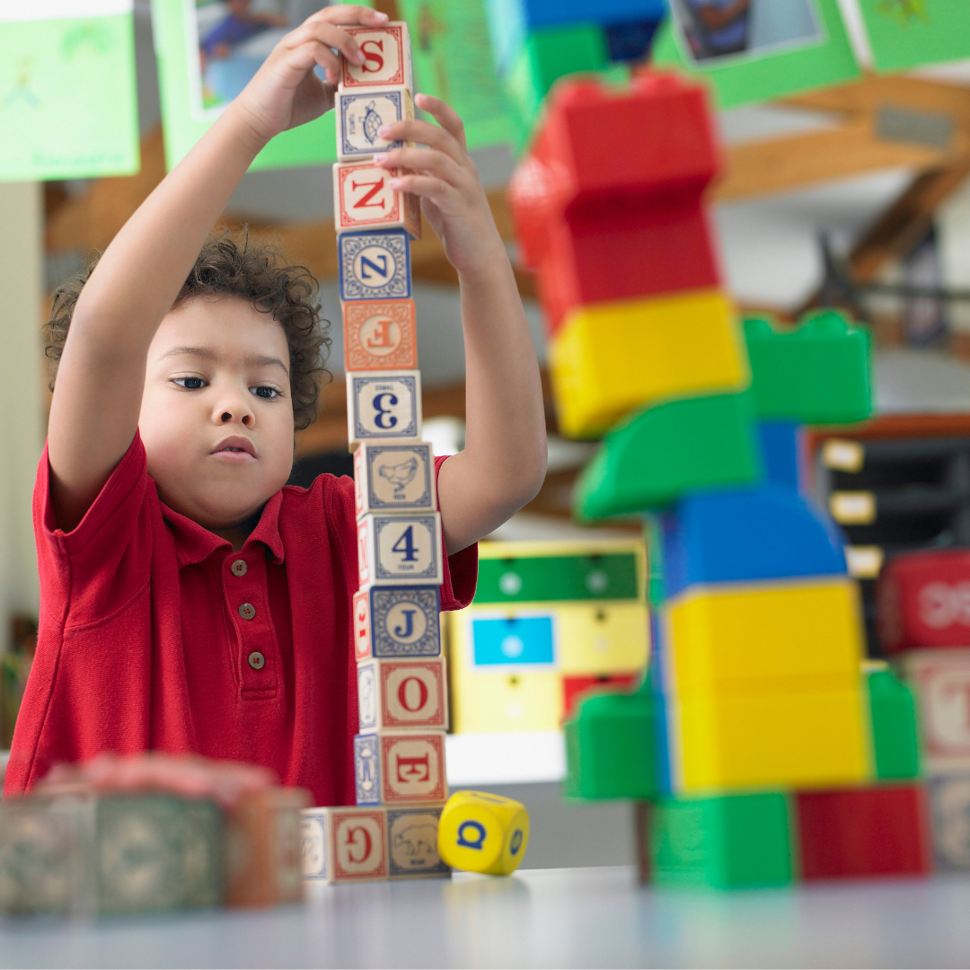 Child stacking alphabet and number blocks