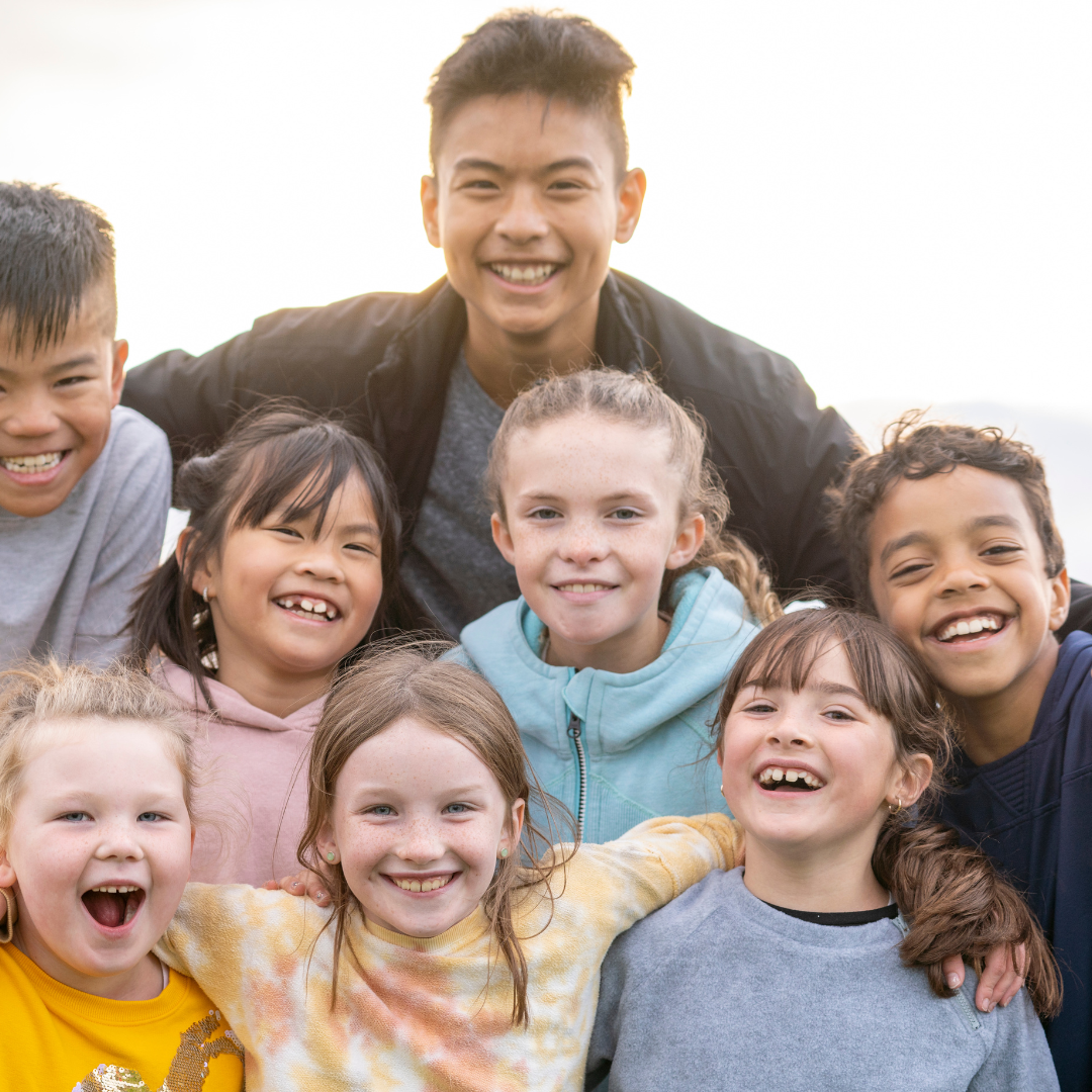 Group of 8 smiling School Age Children outside