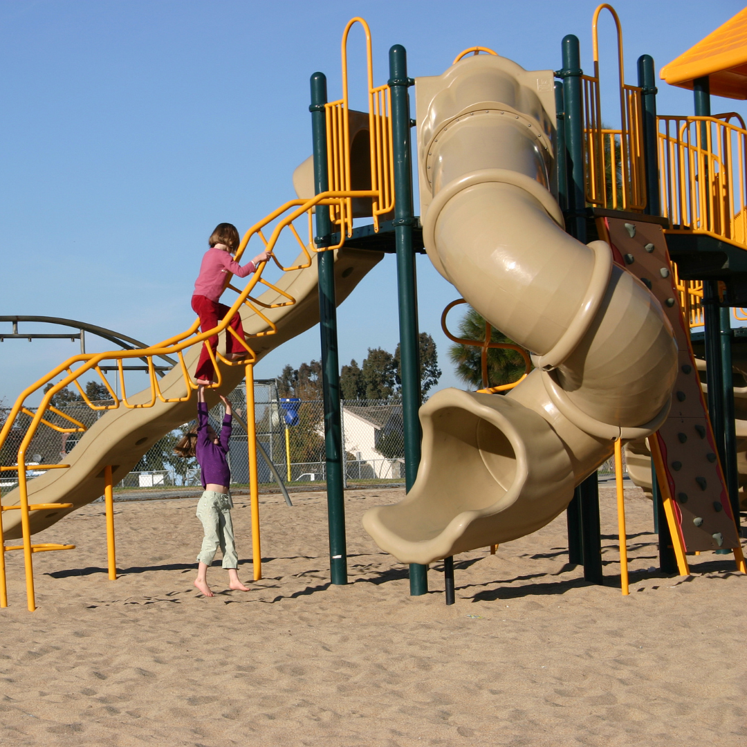 Children outisde in playground with large slide