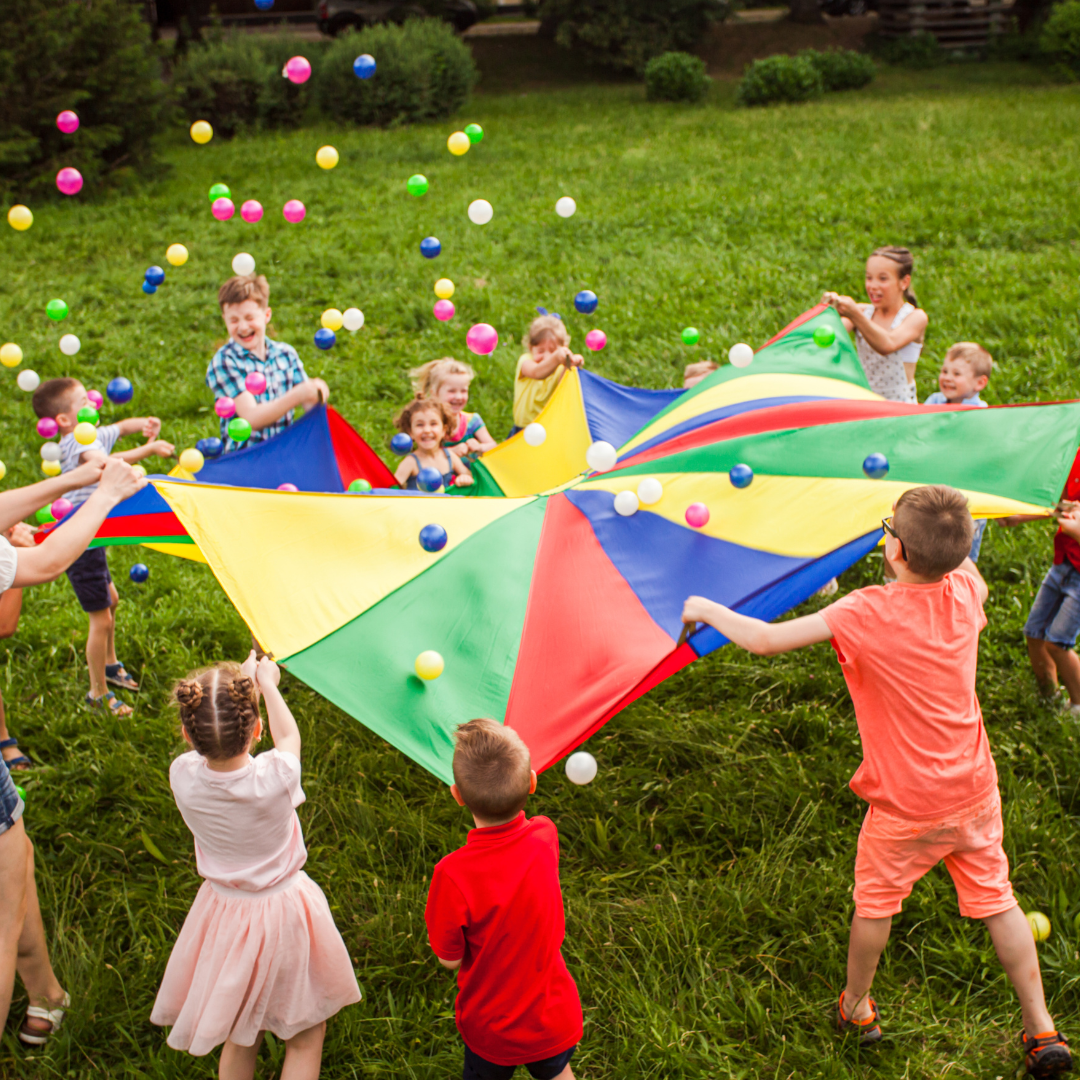 Children doing activity with parachute and balls
