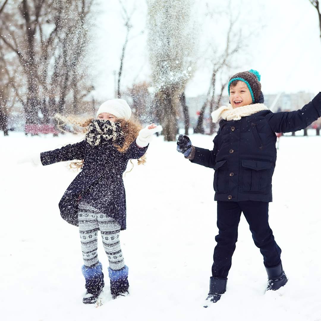 Two kids standing in snowy field