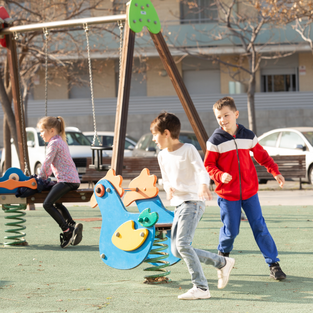 Three children playing outside in playground