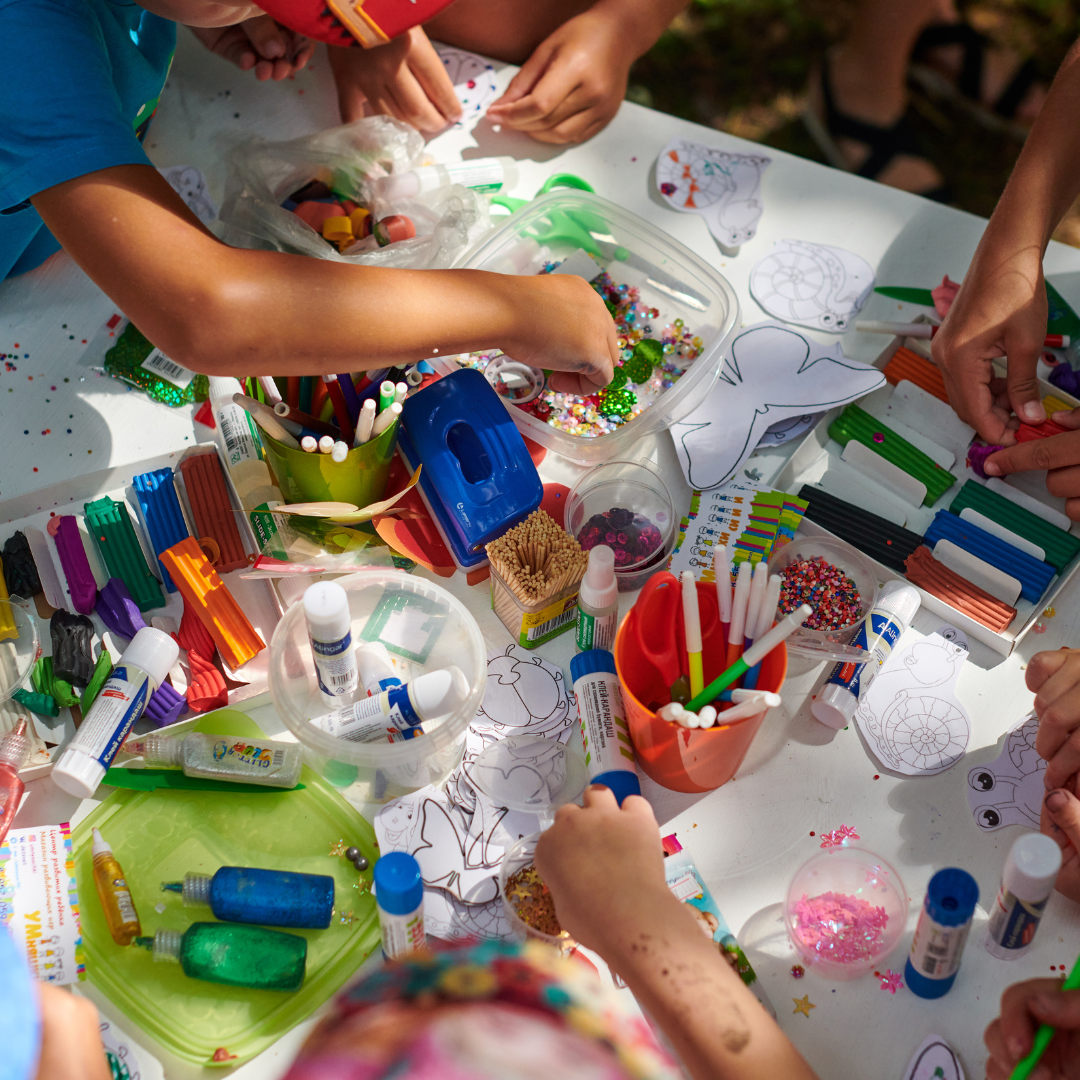 Several sets of hands working on colourful art