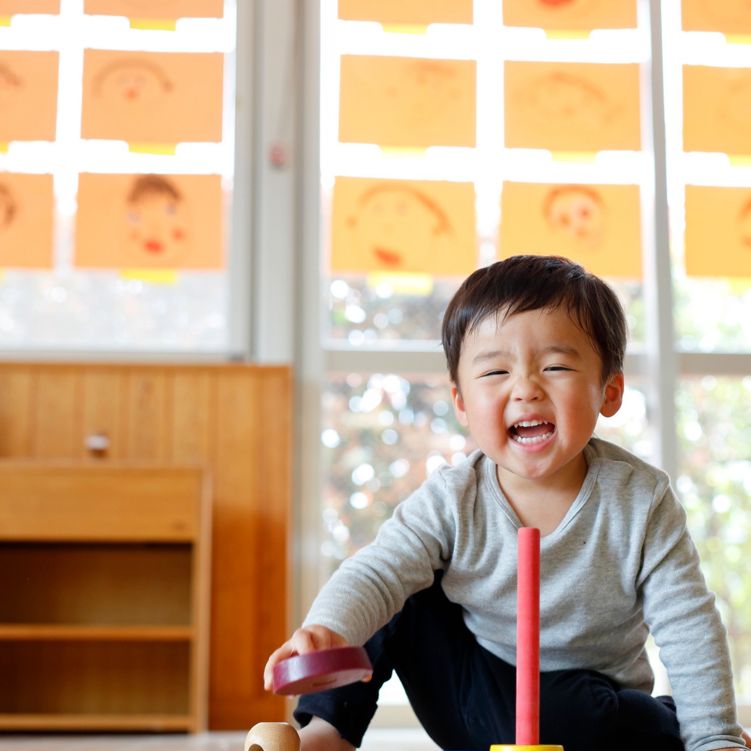 Happy preschool child, doing activity on classroom floor
