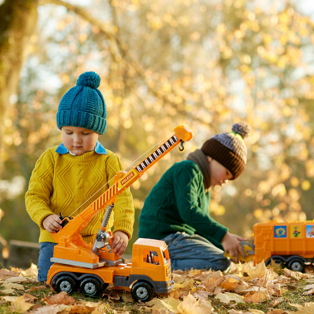 Kids playing outside with toy vehicles in the fall