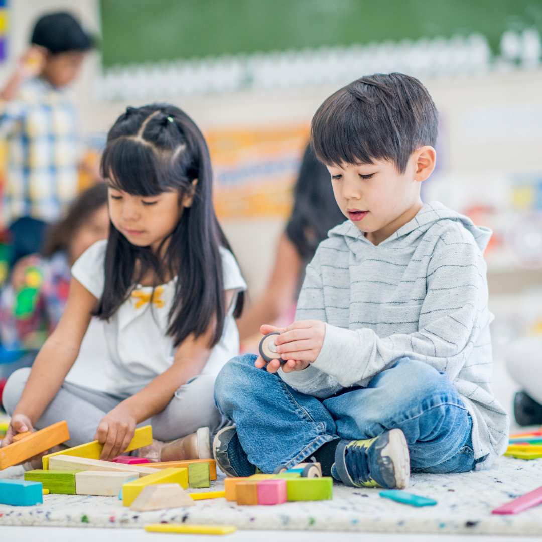 Children sitting on classroom floor doing activities