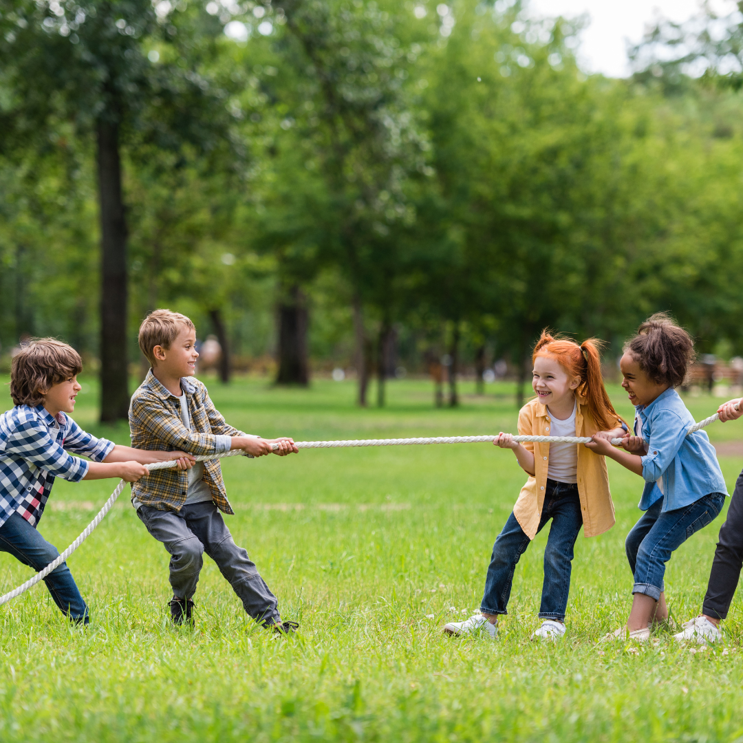 Children outside in two teams pulling on rope