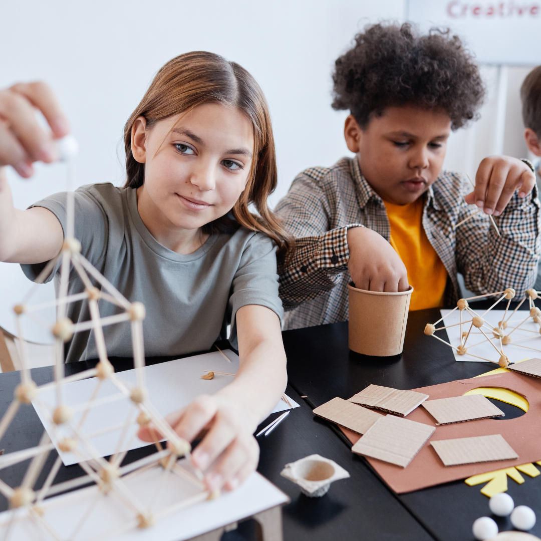 Older schoolagers doing craft activities at a table