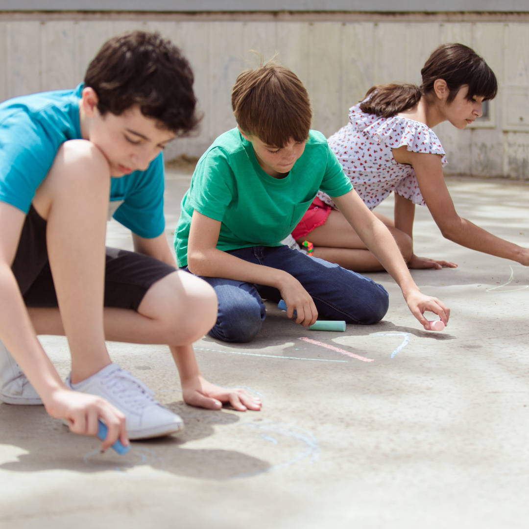 School age kids drawing with chalk outside