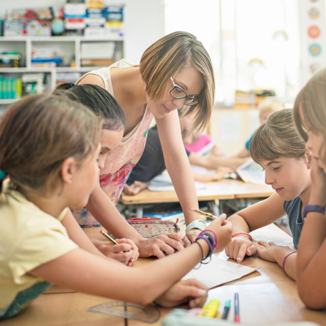 Children and adult at a classroom table working together