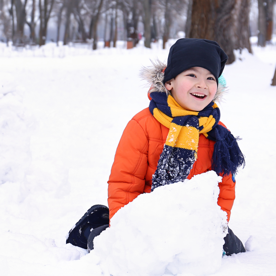 Child rolling big snowball