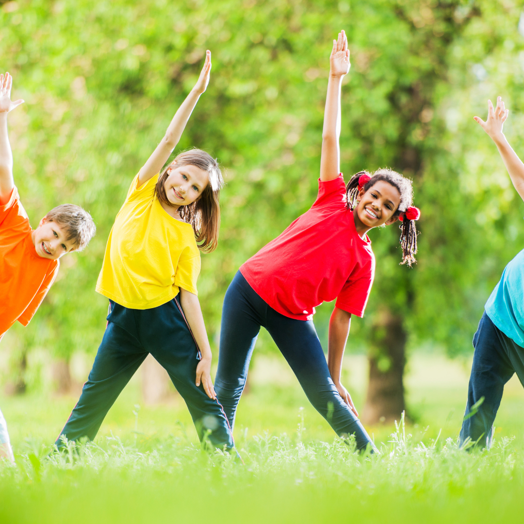 School age kids outside stretching in green space