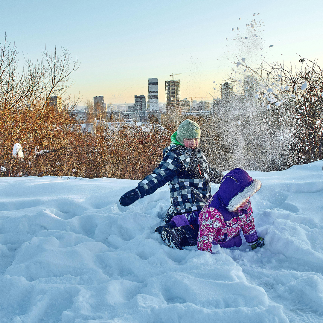 Two children outside in winter playing in snow