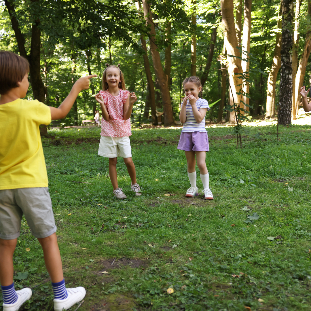 School age children playing outside on grass in summer