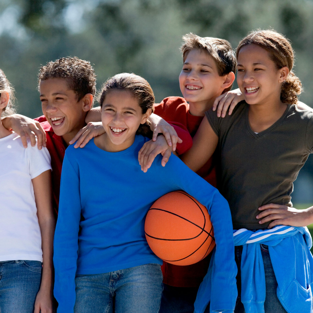 Group of school age kids standing together; one holding a basketball - Before and After School at Canadian Martyrs CES