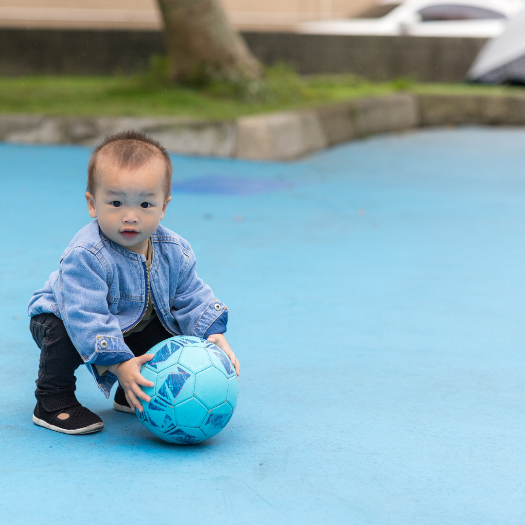 Infant holding a ball