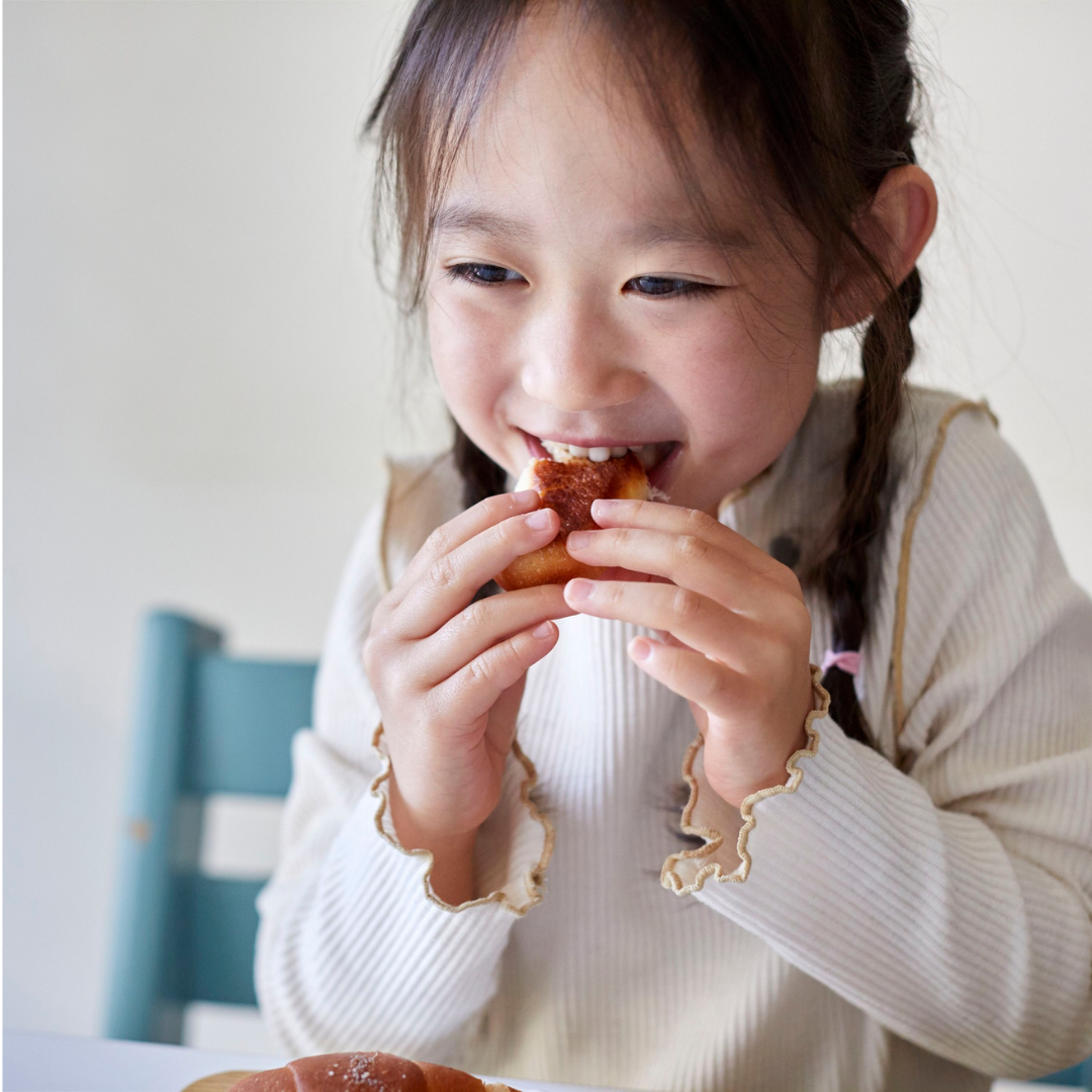 Smiling child, sitting and eating a snack