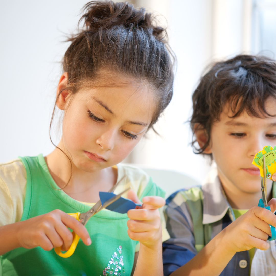 School age kids doing crafts, cutting with scissors