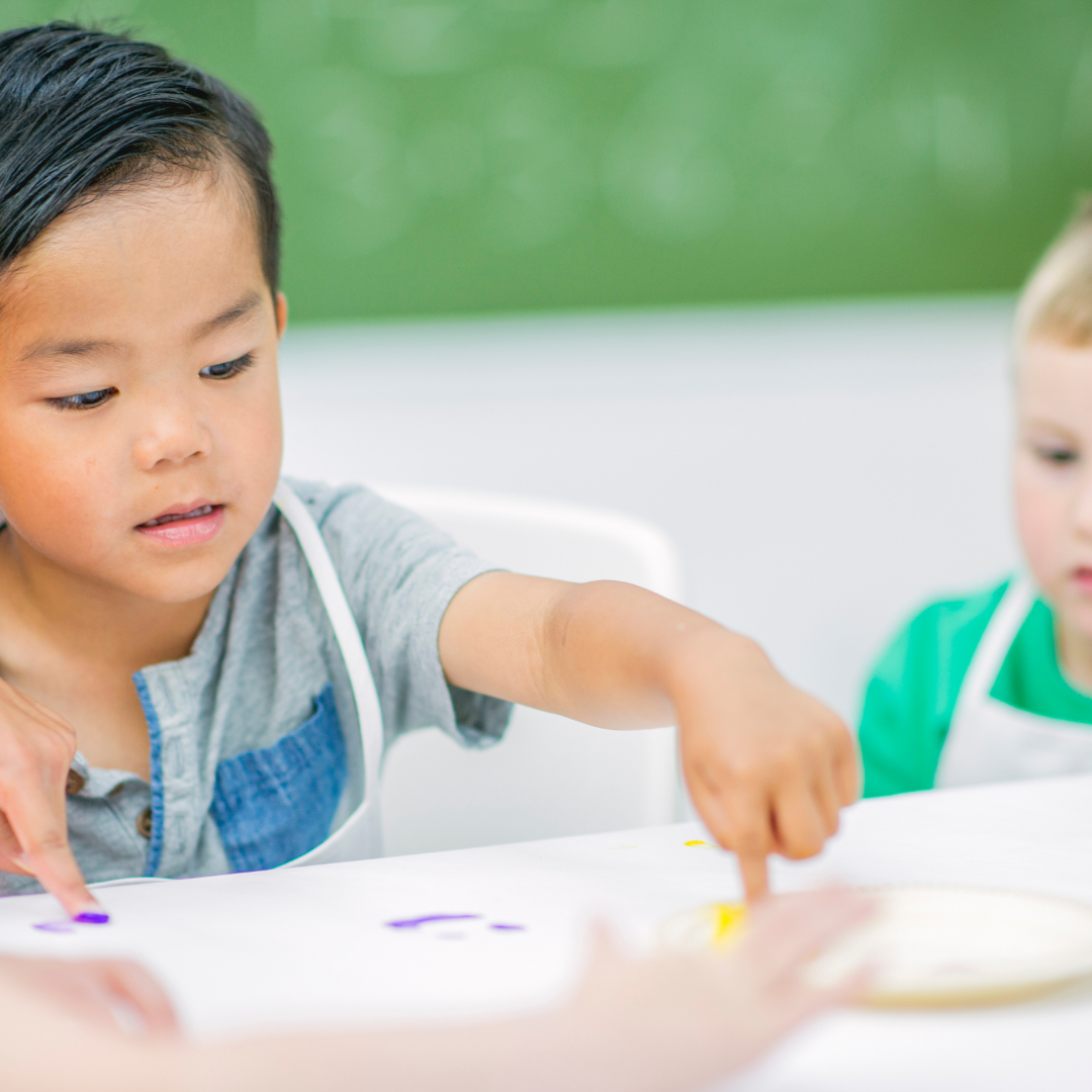 Children wearing aprons doing activity in daycare setting