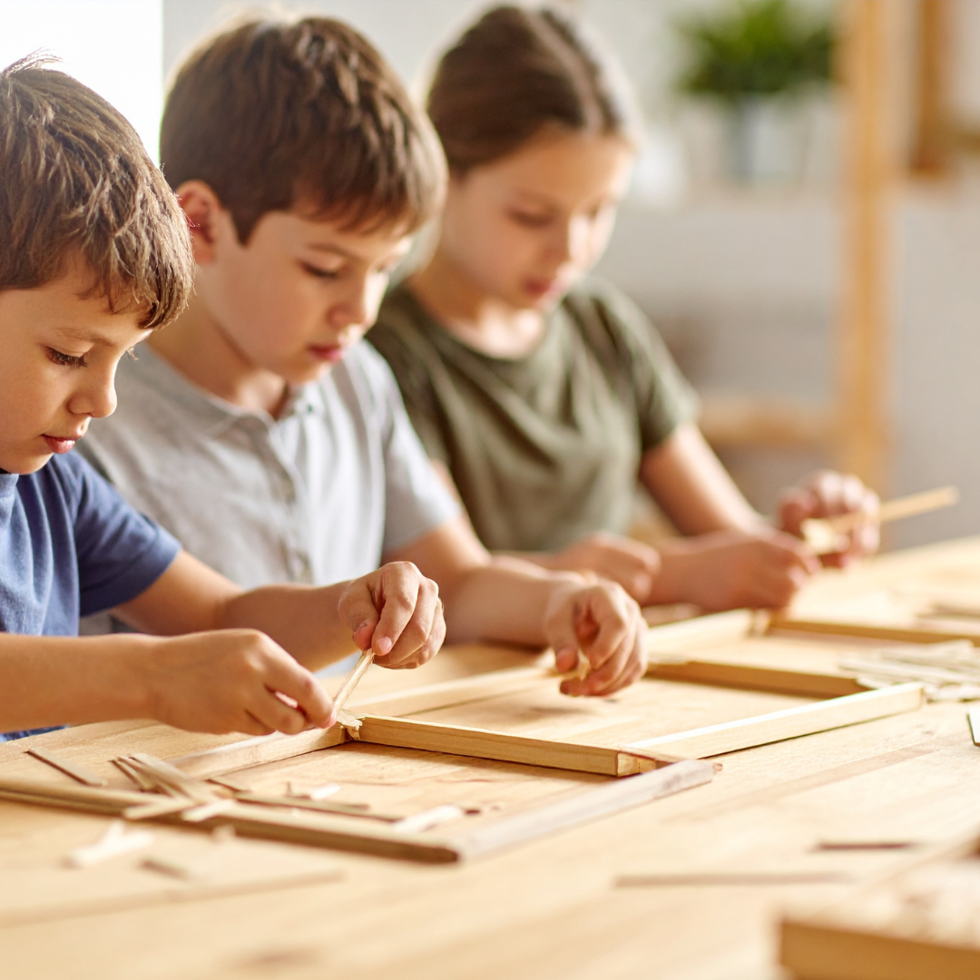 School age kids making wooden frames