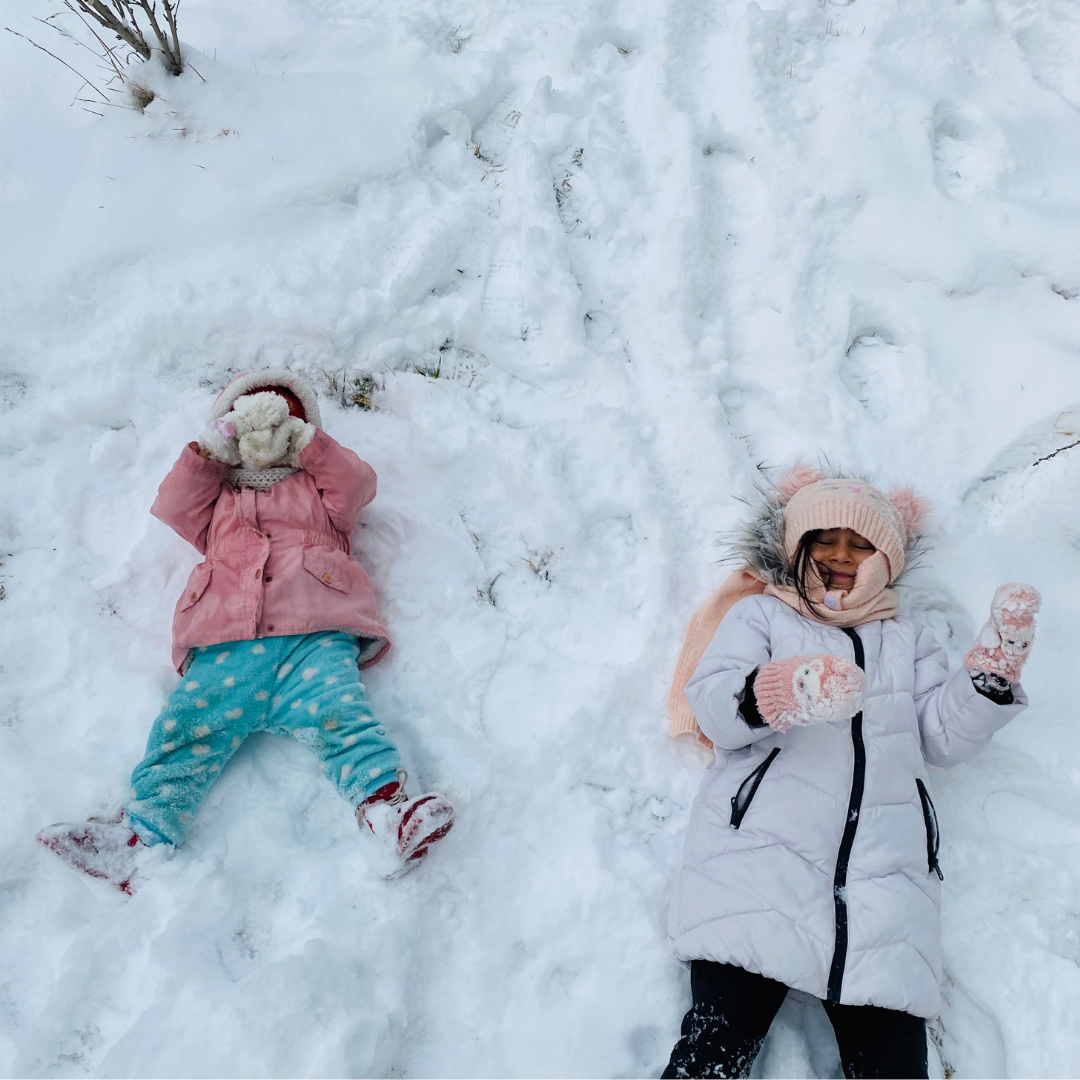 Two kids making snow angels