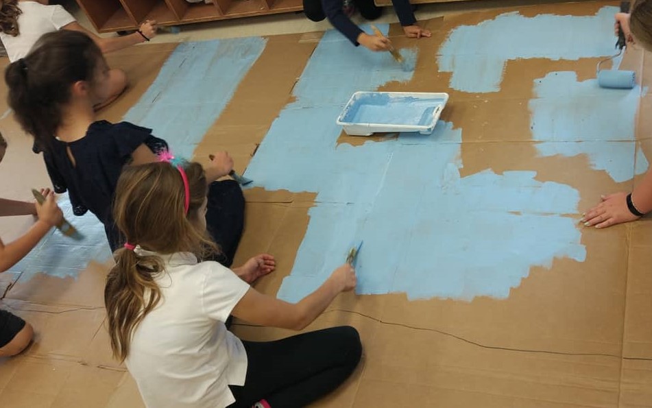 School age children painting with rollers - theatre sets - Before and After School at Holy Name CES