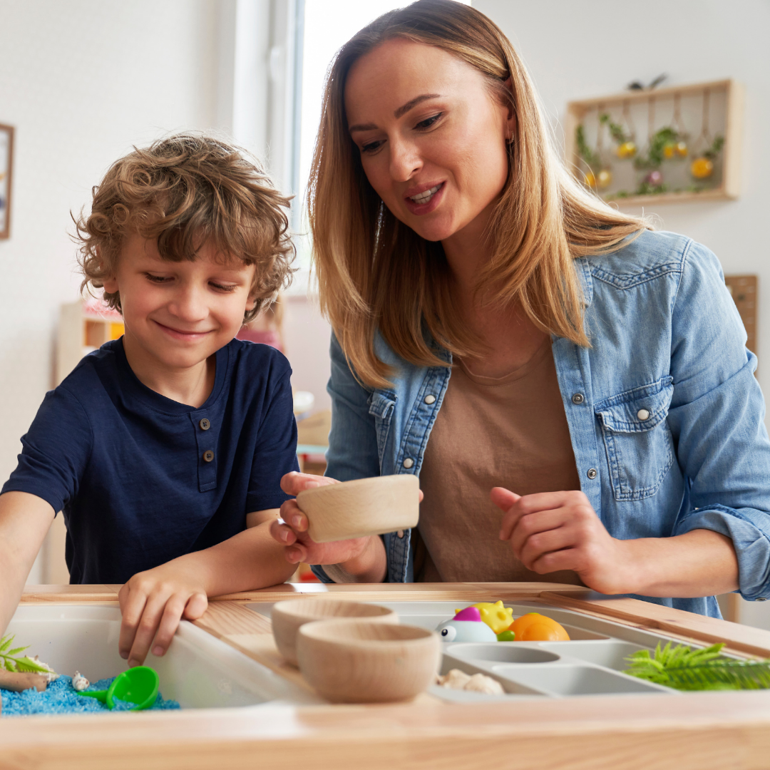 Child and adult doing sensory table activity - Before and After School at Elder's Mills PS