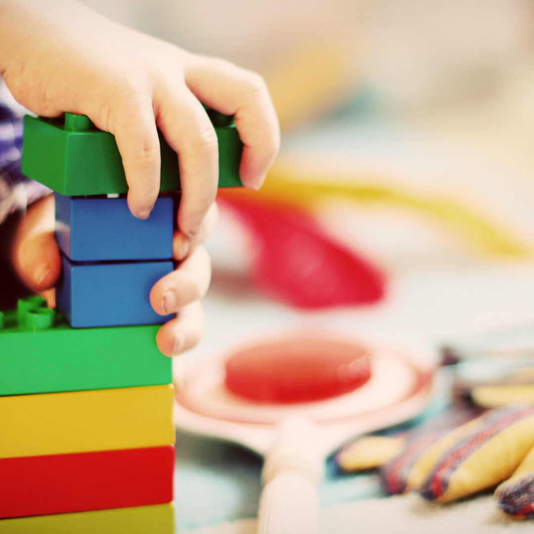 Child's hands, playing with colourful wooden blocks