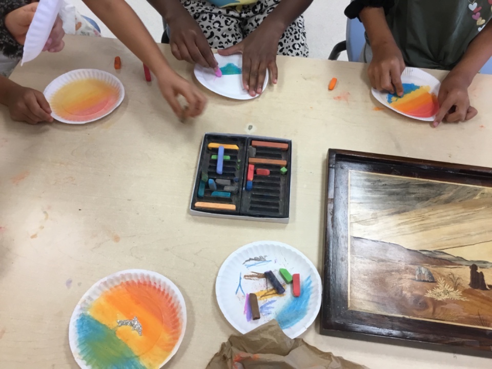 Hands of school age children doing colouring art activity at table