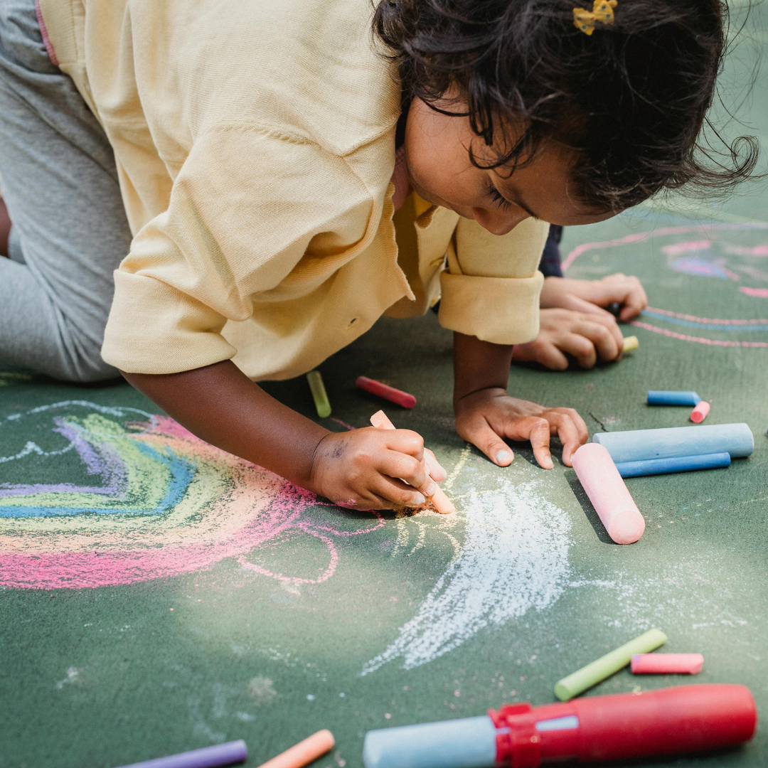 Child drawing with chalk outside - Before and After School at Clearmeadow PS