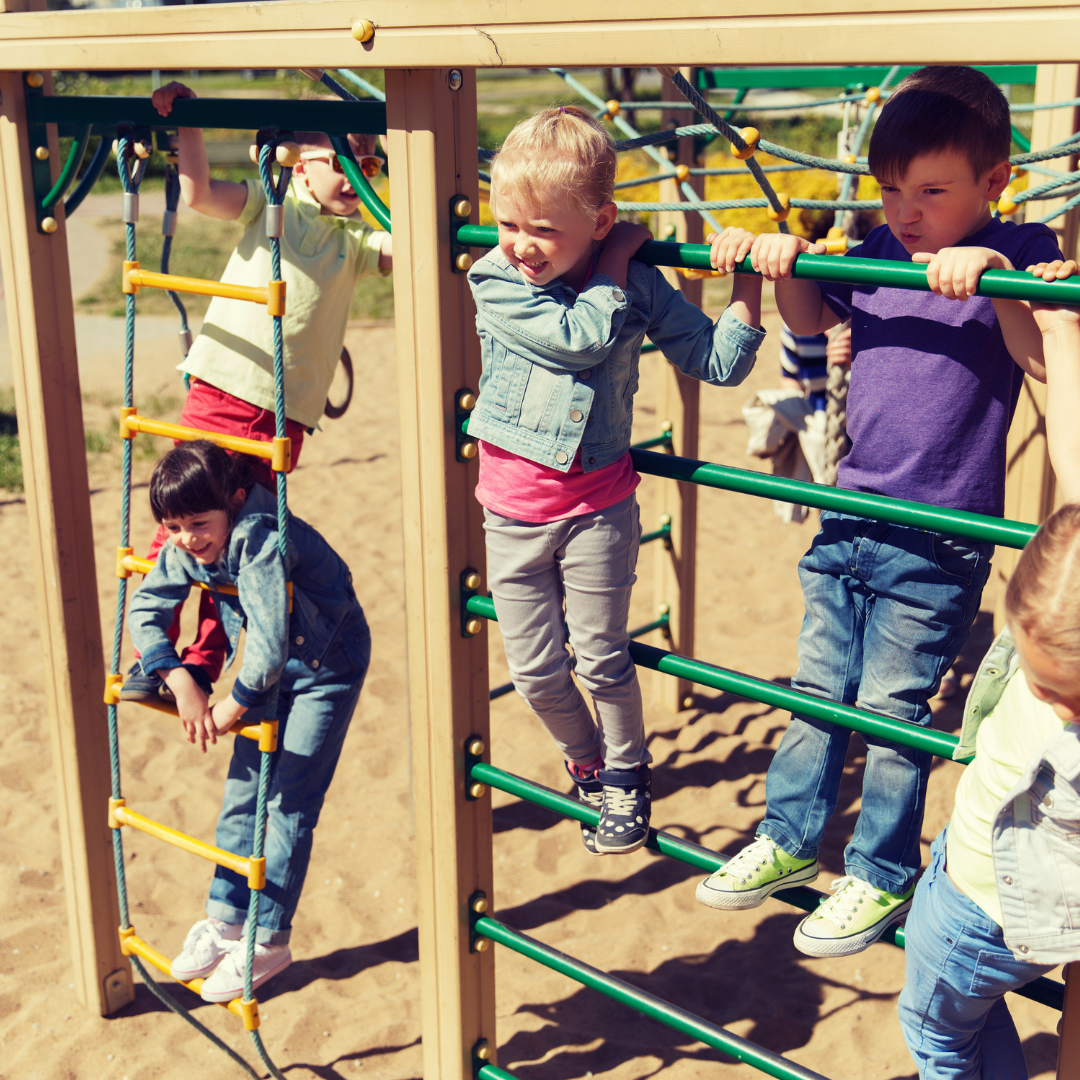 Children outside playing on playground climber