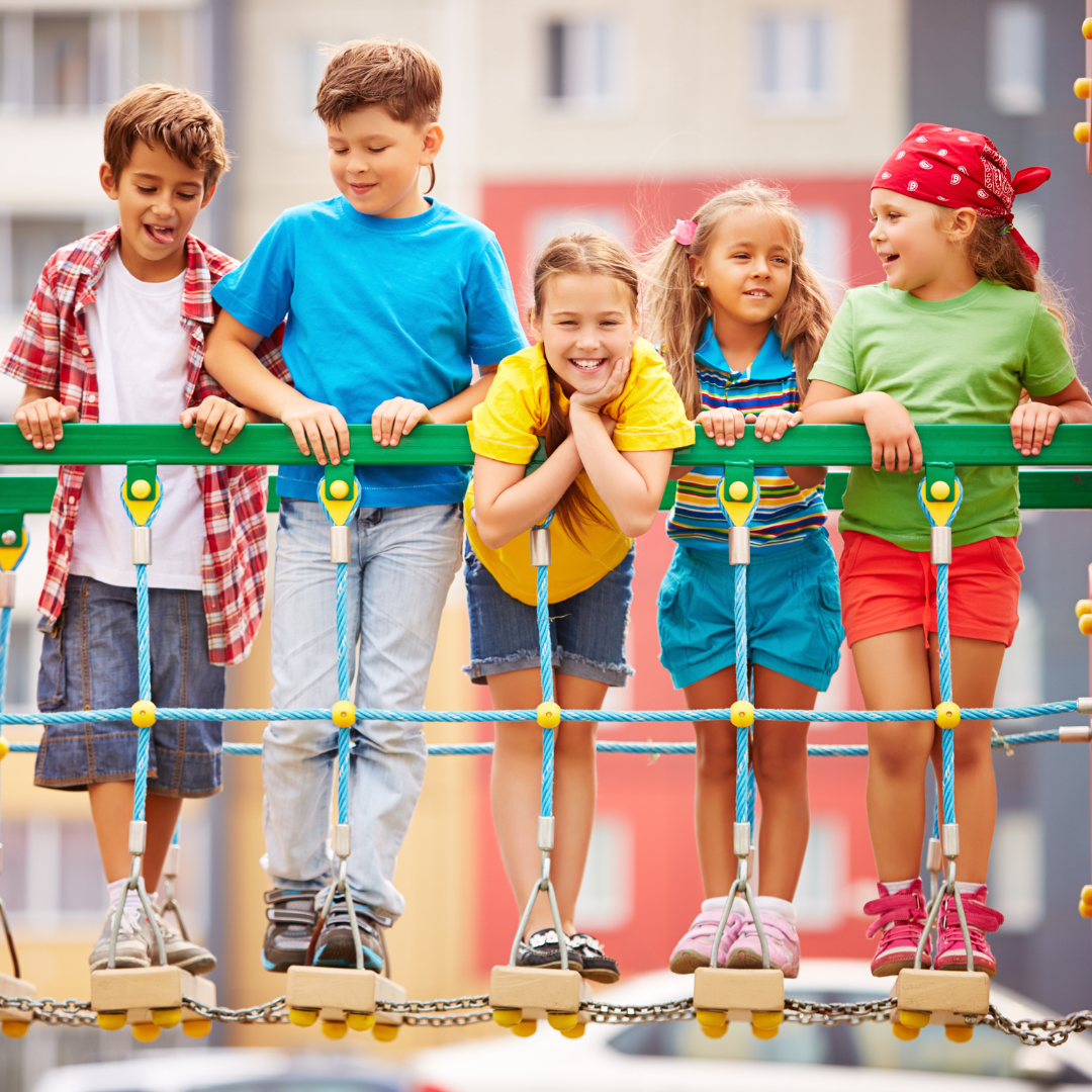 School age kids outside on a playground rope bridge