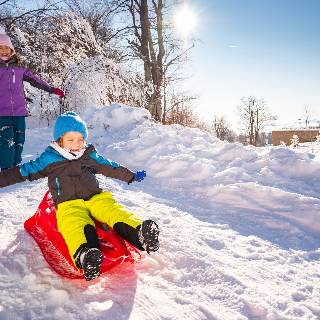 Children sledding on snow - Before and After School at East Oro PS
