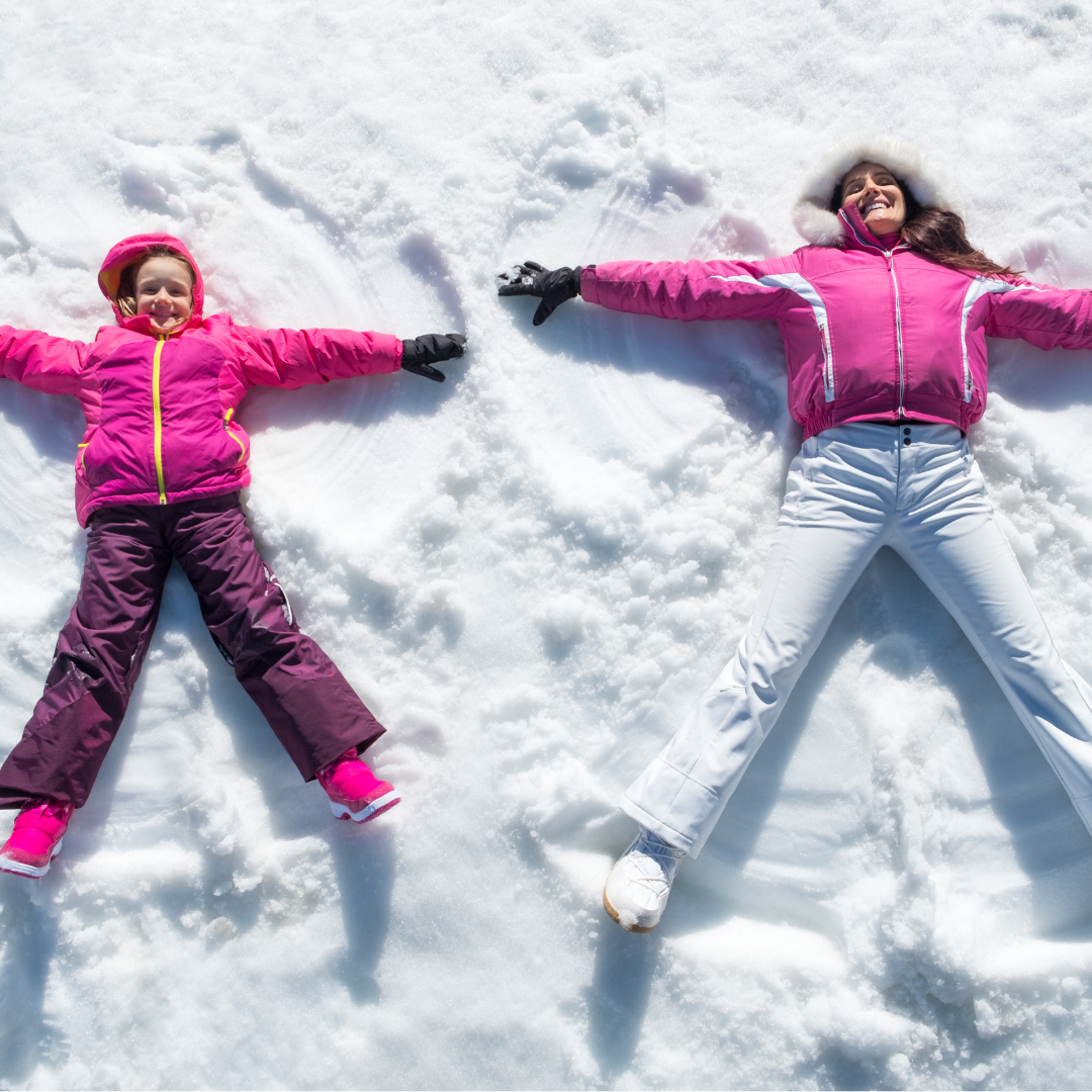 Two children making snow angels outside