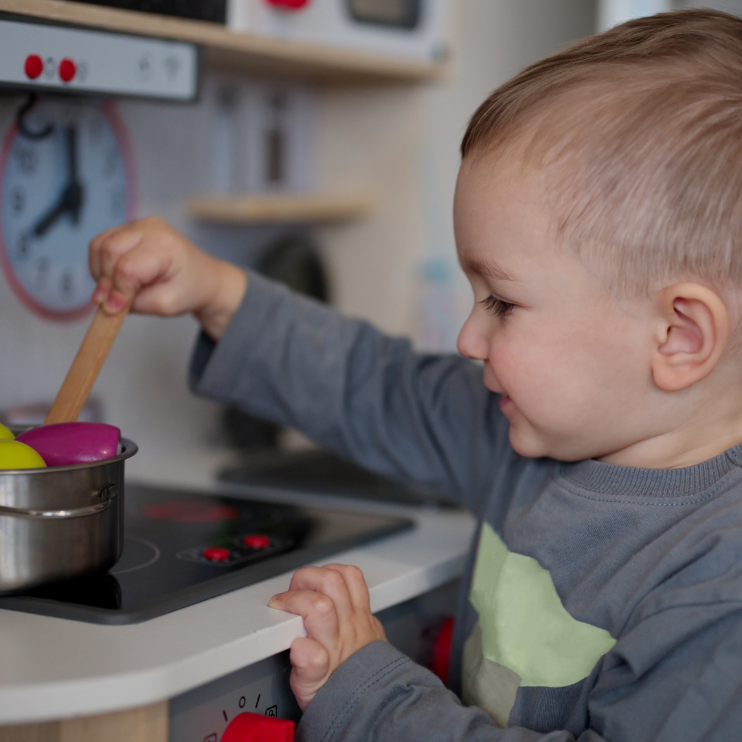 Toddler in play kitchen