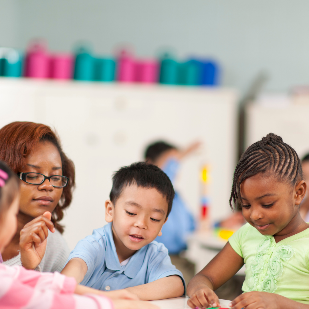 Preschoolers and adult at table doing activities