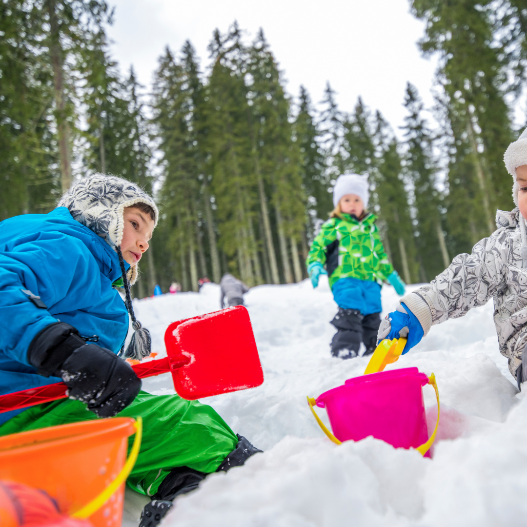 Children playing in snow with buckets and shovels