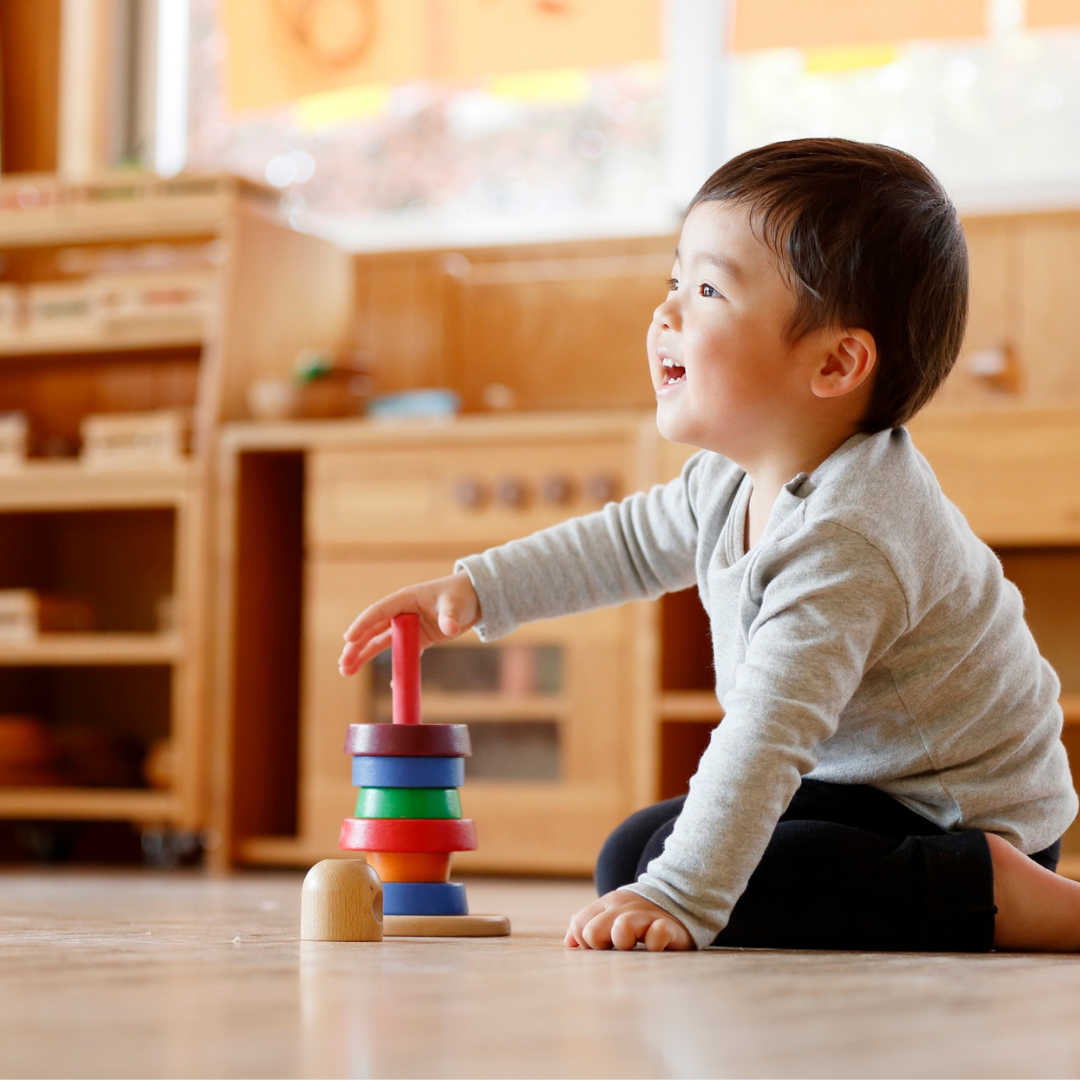 Toddler playing with stacking toy indoors