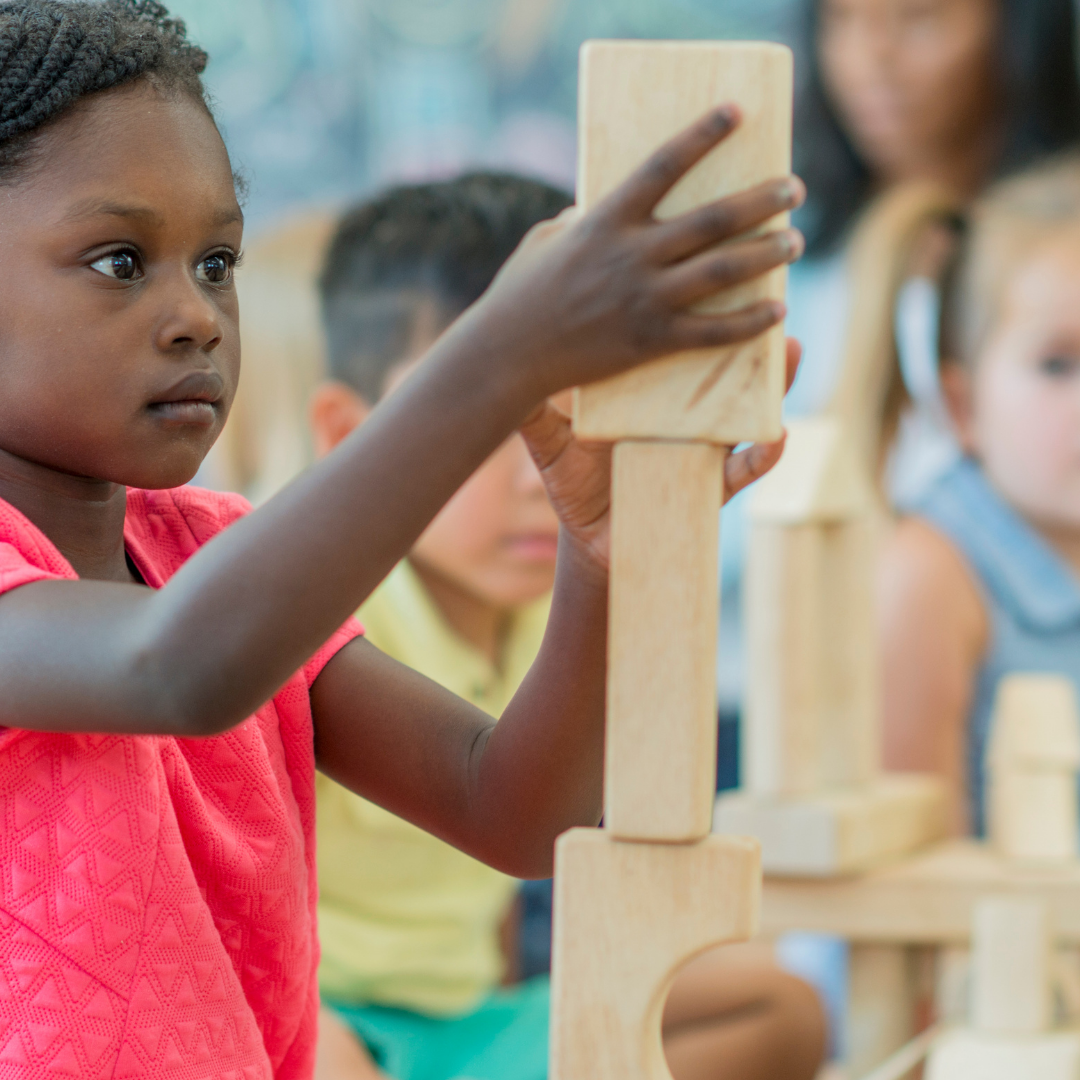 Preschoolers stacking building blocks