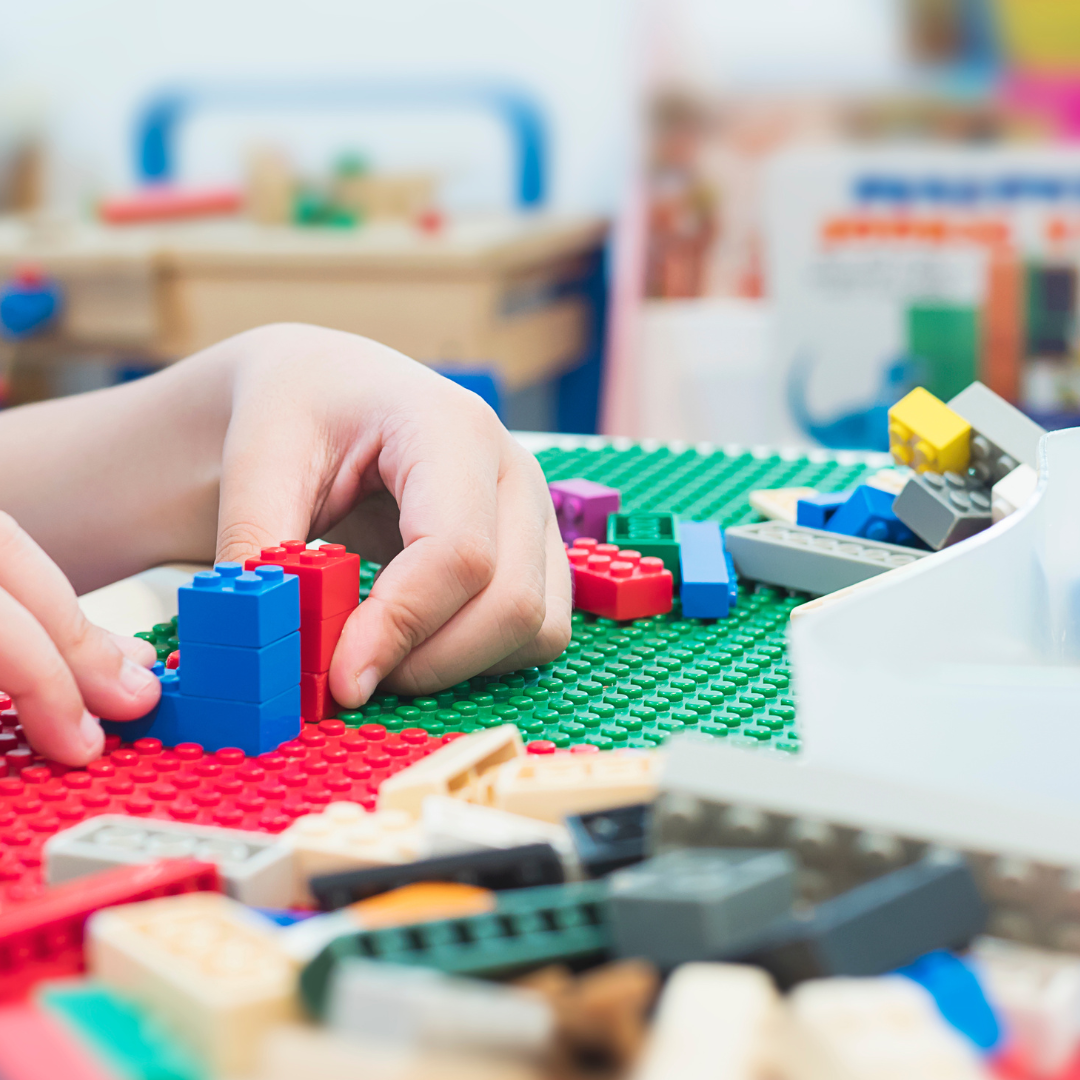 Child's hands building with Lego