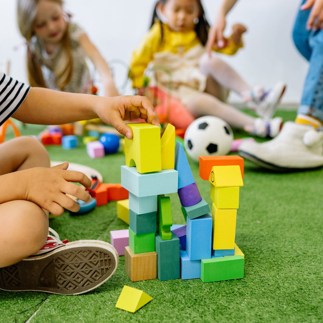 Children sitting and playing with blocks and ball