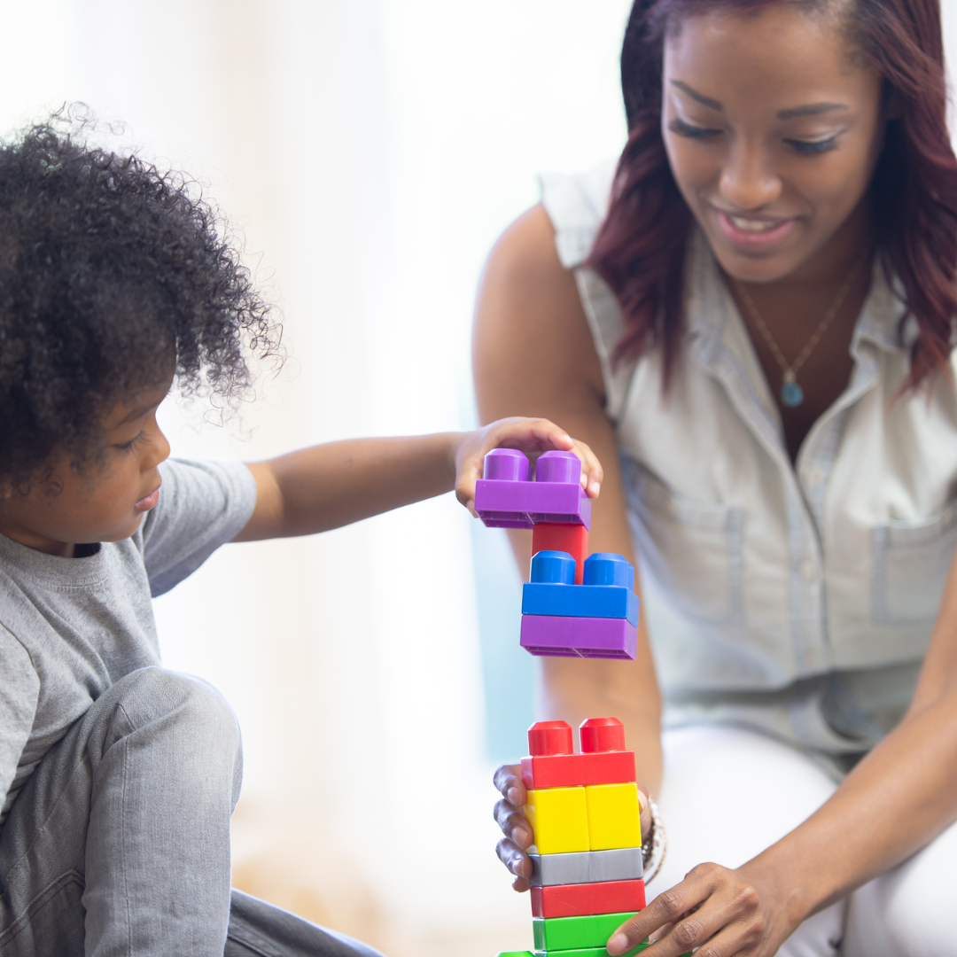 Child and adult stacking building blocks together