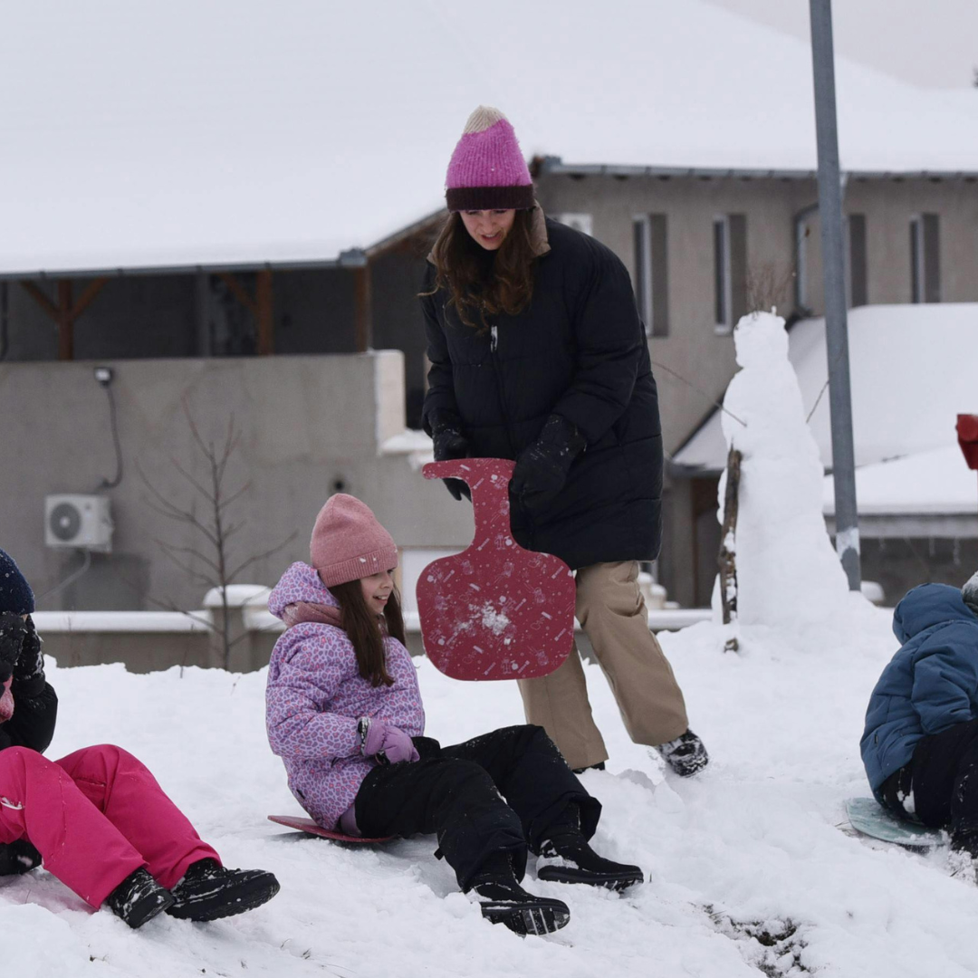 Group of school age children sledding in snow