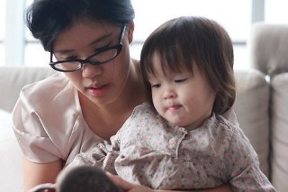 Adult with toddler reading on their lap, reading together