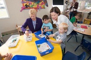 Adults and children at a childcare center doing sensory table activities