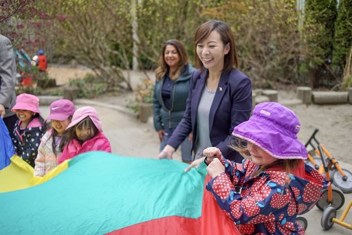 Adults and children playing with a parachute outside