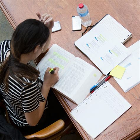 A person studying at a desk with books and papers